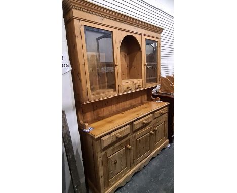 20th century pine dresser with ogee moulded pediment above two glazed doors flanking central shelf, above two short drawers, 