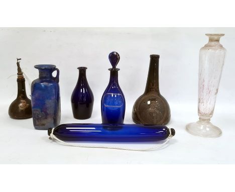 Two old green glass bottles, two various blue spirit decanters, iridescent blue flask, square, blue glass rolling pin and one