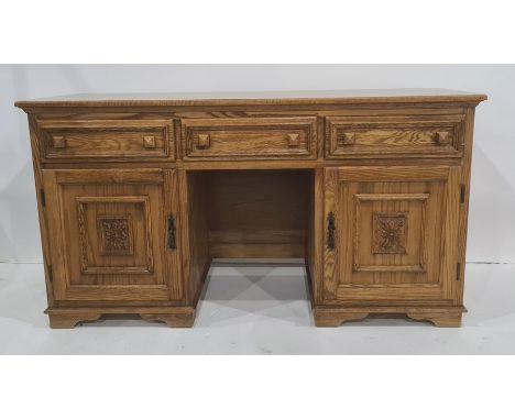 20th century oak sideboard, the rectangular top above three drawers, two cupboard doors and central open kneehole, all on bra