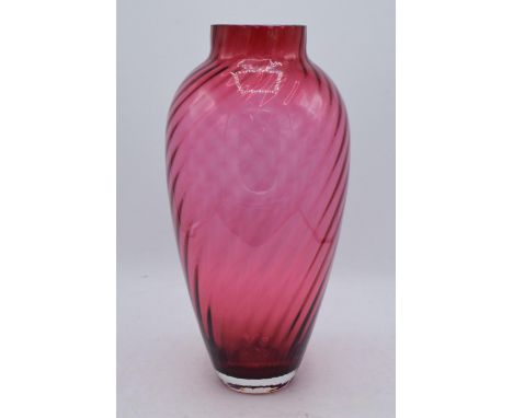 A large vintage cranberry glass with swirling decoration, 35cm tall. In good condition with no obvious damage or restoration.