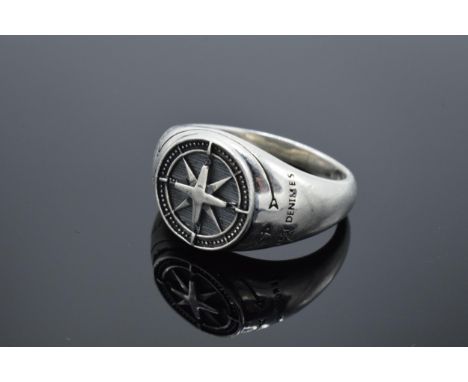 A large chunky silver gents ring with compass-style decoration. 