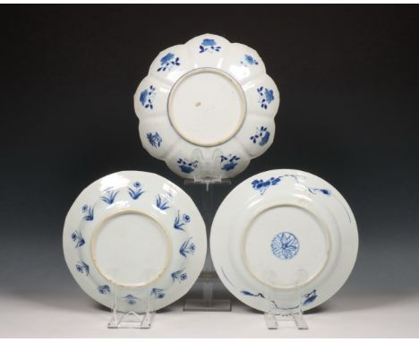 China, drie verschillende blauw-wit porseleinen borden, Kangxi periode (1662-1722), een in lotusvorm en gedecoreerd met bloem