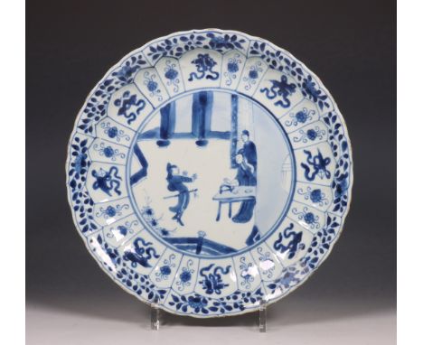 China, blauw-wit porseleinen bord, Kangxi periode (1662-1722), gedecoreerd met een interieurscène omgeven door panelen met sy