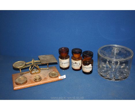 A cheese preserver glass bowl, three brown medical bottles and a set of postal scales