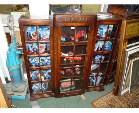 A 1940's glazed Oak three door breakfront Bookcase, the three ten pane doors opening to reveal ten adjustable shelves, on bra