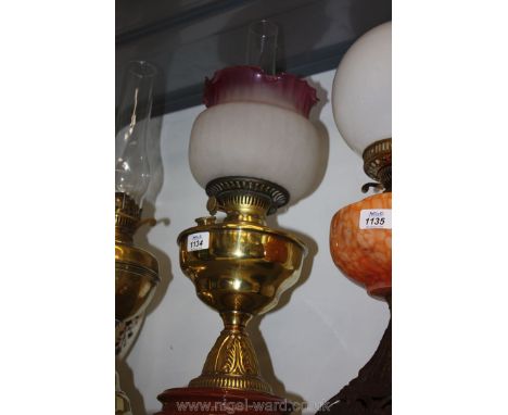 A brass Oil Lamp and red shade