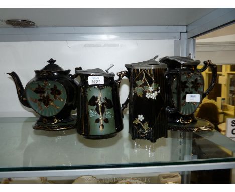 A quantity of Jackfield china including a teapot and stand, hand painted with ivy leaves and fruit together with three hot wa