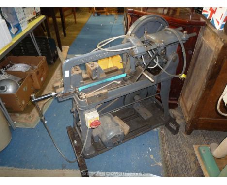 A 240 volt electric hacksaw mounted on a wheeled base.