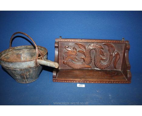 A wood hanging wall shelf with carving of a sea creature and a galvanized container