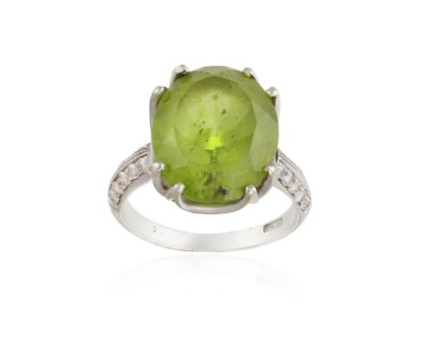 			A PERIDOT AND DIAMOND DRESS RING, the oval mixed-cut peridot weighing approximately 8.50cts, within a double four-claw set