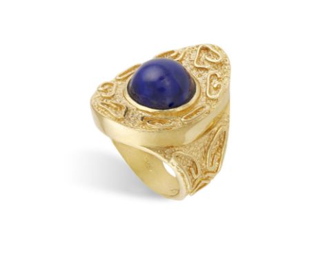 A LAPIS LAZULI AND GOLD RING CIRCA 1970, composed of a central round-shaped cabochon lapis lazuli within a textured gold fram