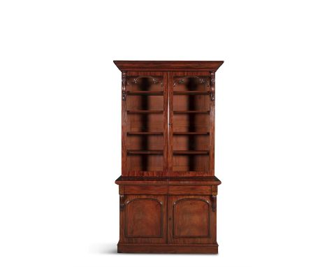 A VICTORIAN TWO DOOR MAHOGANY BOOKCASE, with moulded cornice above twin glazed doors, flanked by carved brackets with shelved