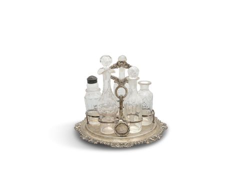 A GEORGE III IRISH SILVER CRUET STAND, Dublin c.1818, mark of Edward Power, the seven ring compartment on a shaped circular b