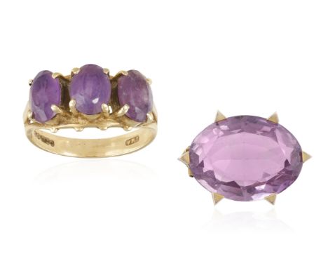 AN AMETHYST BROOCH WITH AN AMETHYST THREE-STONE RING, the brooch set with an oval mixed-cut amethyst weighing approximately 2