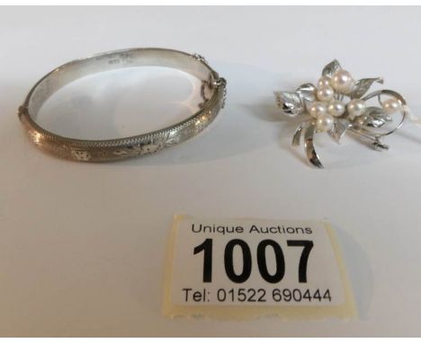 A vintage cultured pearl brooch set with 8 pearls together with a silver bangle