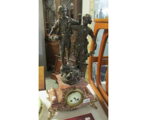 A French mantel clock surmounted pair of figures