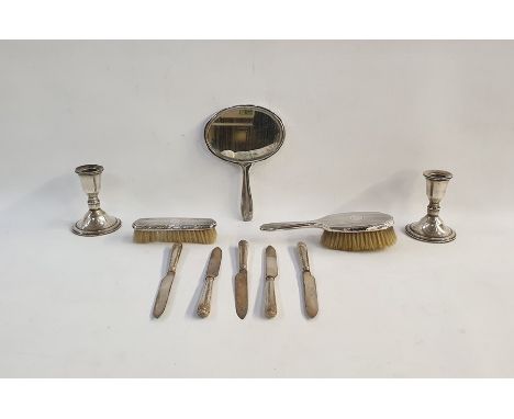Pair of silver weighted candlesticks marked 'Sterling', a silver-backed mirror with engine-turned decoration, a silver-backed
