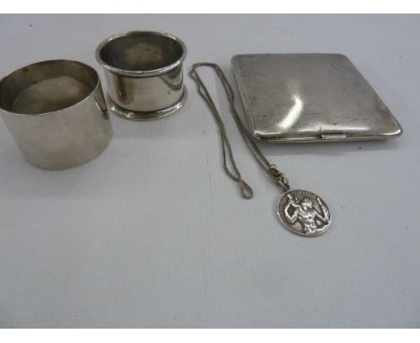 Two silver napkin rings, silver cigarette case, engine turned, and a silver St. Christopher pendant on chain