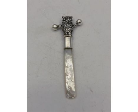 A silver owl shaped Babies rattle with mother of pearl handle