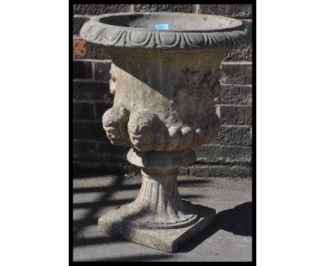 An early 20th Century reconstituted stone garden urn planter, well weathered&nbsp;fluted socle and platform base&nbsp;raised 