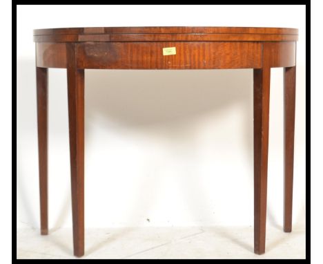 A 19th century George III mahogany demi lune tea table / games card table. Raised on square tapering legs , above a fitted fr