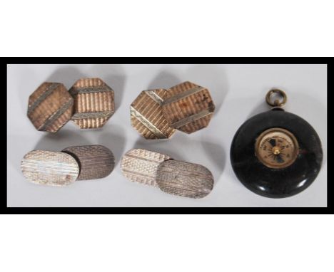 Two pairs of early 20th Century Art Deco cufflinks both having engine turned decoration. One of oval form and the other of oc