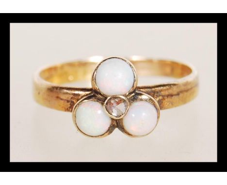 A 20th Century 9ct gold ring set with three opal cabochons. Marks rubbed but tests as 9ct. Weight 1.9g. Size K.