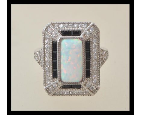 A stamped 925 silver Art Deco style ladies dress ring set with a central opal panel, set with cz and sapphire accent stones. 