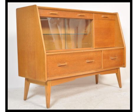 A vintage retro 20th Century E Gomme G-Plan oak cocktail cabinet sideboard credenza unit raised on tapering legs with drawers