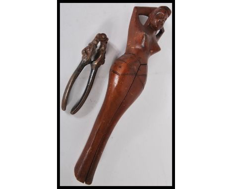 Two pairs of vintage nut crackers to include a pair of wooden ones modelled as a naked lady and the other cast metal pair wit