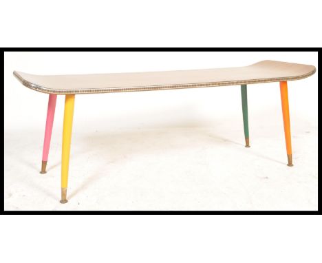 A vintage retro 20th Century teak coffee table of surfboard rectangular shape raised on tapering legs painted in different co