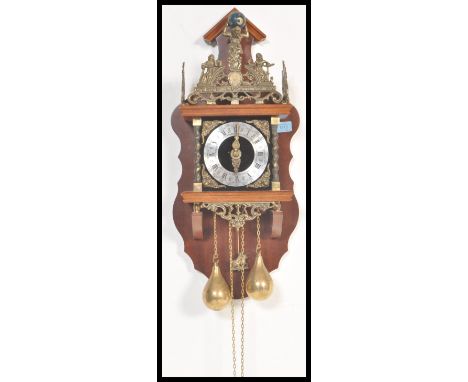 A 20th Century Dutch oak lantern-type Zaanse wall clock, marked around the fret mounts 'Nu Elck Syn Sin', the two bells above