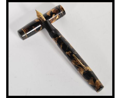 A vintage 20th Century Mentmore autoflow lever fill fountain pen having a 14k gold nib with brown marble effect body. Measure