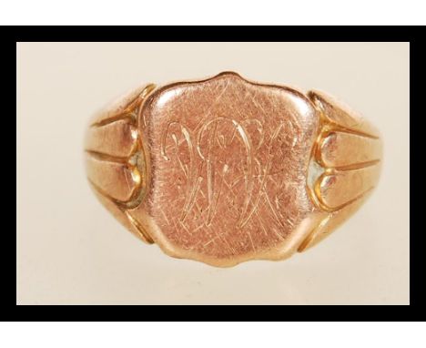 A hallmarked 9ct gold signet ring having a cartouche panel engraved with AM initials having reeded shoulders. Hallmarked Birm