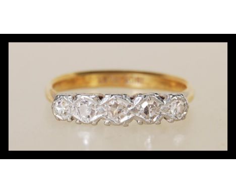 An 18ct gold and platinum five stone diamond ring having five claw set diamonds. Size K.5. Weighs 2 grams.