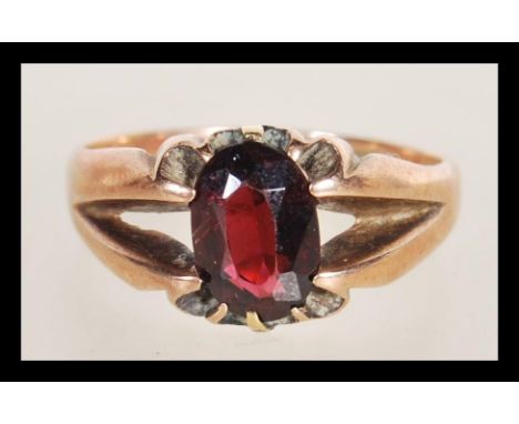 A hallmarked 9ct gold ring having a split shank design set with an oval cut garnet. Hallmarked Chester 1915. Weight 4.0g. Siz