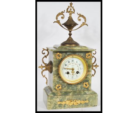 A 19th Century French Empire mantel clock having a green marble case. The white enamel face having Roman numeral chapter ring