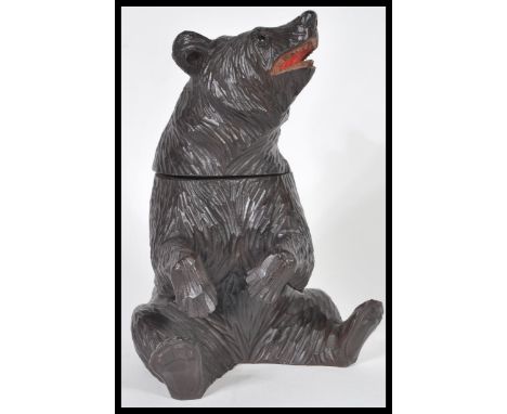 A German Black Forest hand carved wooden tobacco pot or tea caddy in the form of a bear having hinged lid to head. 21.2cm hig