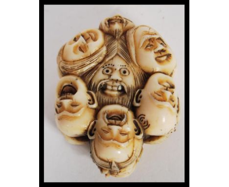 A 20th Century Japanese netsuke or toggle of composite ivory or bone effect in the Twelve Faces pattern. Measures 2.5cm high 