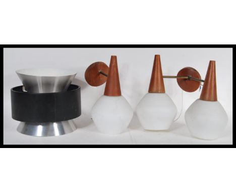 A vintage retro 20th Century wall light having a circular teak wall mounts with two brass arms and white glass shades along w