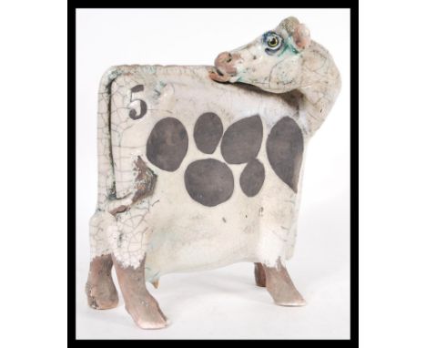 A vintage retro 20th Century Raku studio art pottery figurine of a cow of square form having bold no 5 to body. Measures 24cm