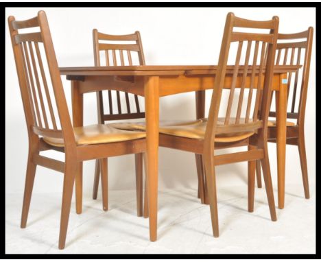 A vintage retro 20th Century teak Danish influence dining table suite with a set of four vintage teak wood chairs. The extend