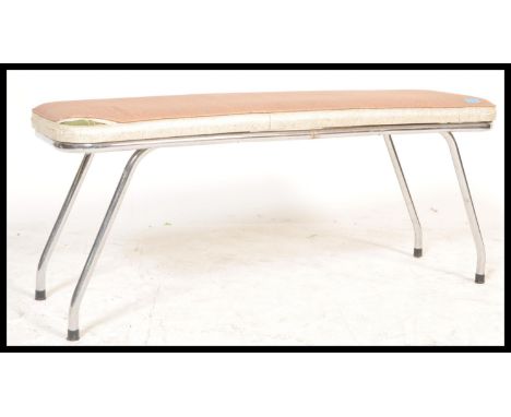 A 20th Century vintage retro bench having a beige vinyl padded seat being raised on four chromed legs, originally taken from 