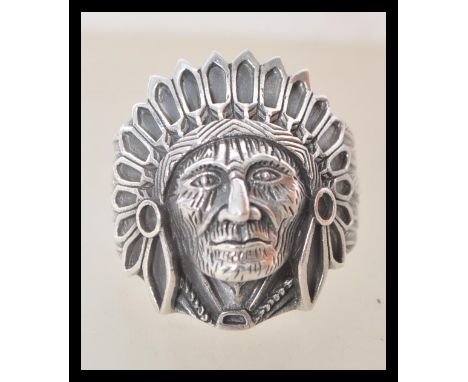 A stamped 925 silver ring in the form of a Native American wearing a feathered head dress. Weight 10.1g. Size T.