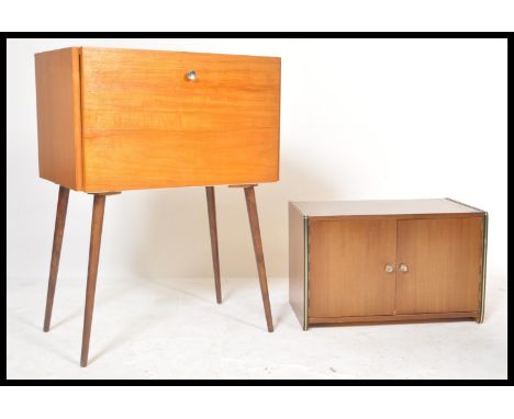 A retro 20th Century teak wood fall front vinyl record cabinet, the fall front opening to reveal sectional interior raised on