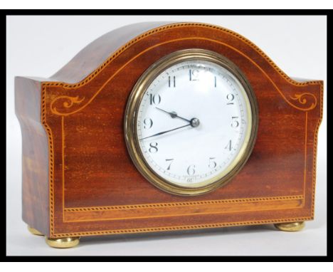 An early 20th Century French mahogany mantel clock having inlay decoration. The white enamel face having bold numeral chapter