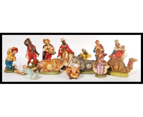 A vintage 20th Century composite Italian nativity set, consisting of Jesus in a crib, three wise men, shepherd, cattle, music