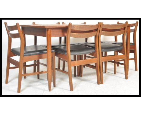 A vintage retro 20th Century teak Danish influence dining table suite with a set of six vintage teak wood chairs. The extendi