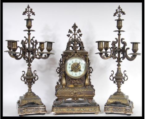 A 19th Century Victorian clock and garniture set consisting of a brass mantel clock having gilt brass dial with&nbsp;white en