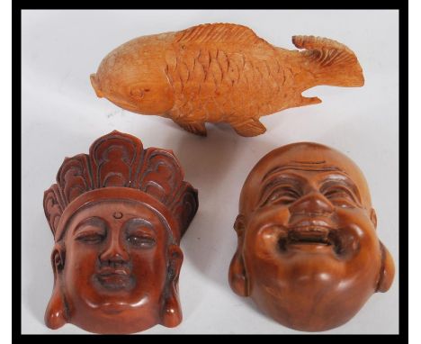 A group of three Japanese wooden hand carved netsukes to include a Meiji period Buddha head bearing signature to verso, a car